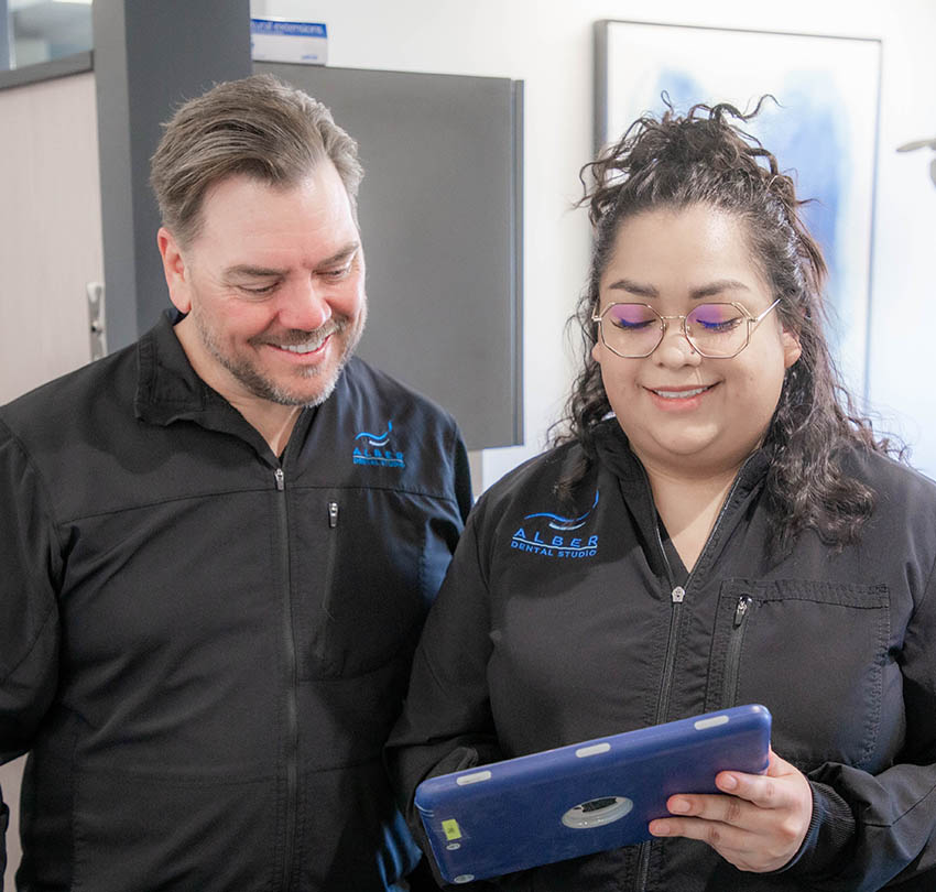 aDr. Marc Alber and a team member discussing a patient's restorative treatment plan at Alber Dental Studio in Boulder, CO