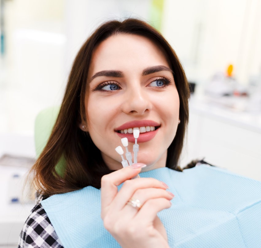 Girl chooses color of veneers at the dentist office