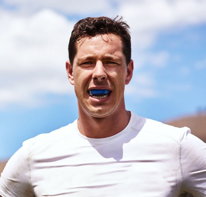 A man wearing a blue mouthguard, showcasing dental protection at Sport Guards in Boulder, CO.