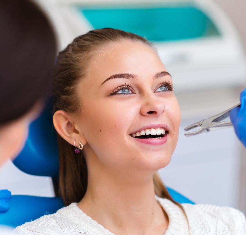 A woman happily undergoing a teeth cleaning procedure, highlighting tooth extractions in Boulder, CO
