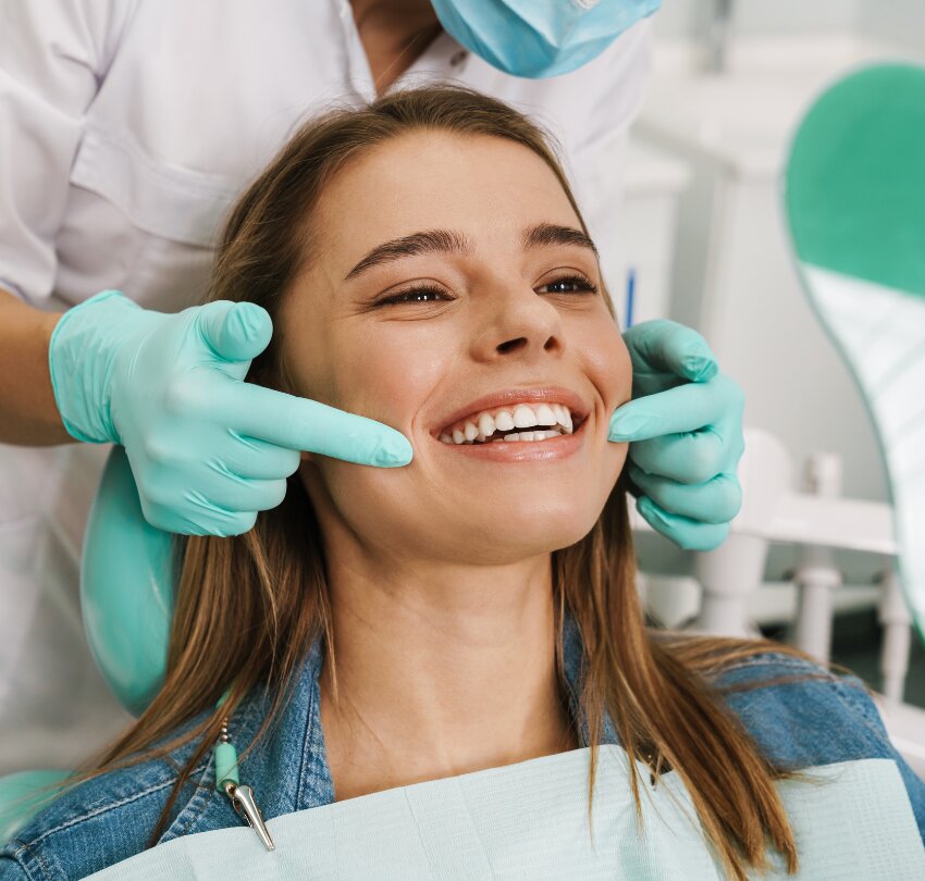 European young woman smiling while looking at mirror in dental clinic